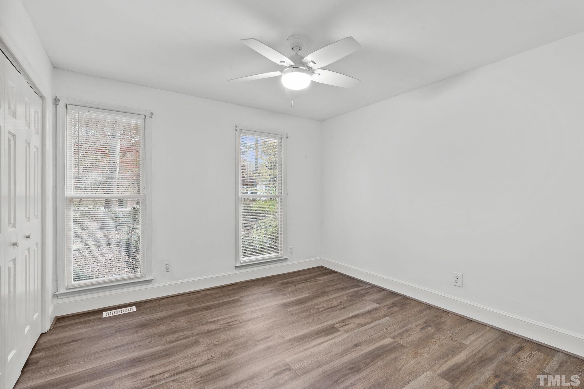 805 Van Thomas Drive Raleigh, NC 27615 - Photo 21 of 38 an empty room with wooden floor chandelier fan and windows