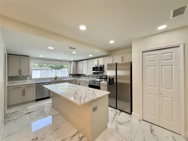 a kitchen with stainless steel appliances granite countertop a sink stove and refrigerator