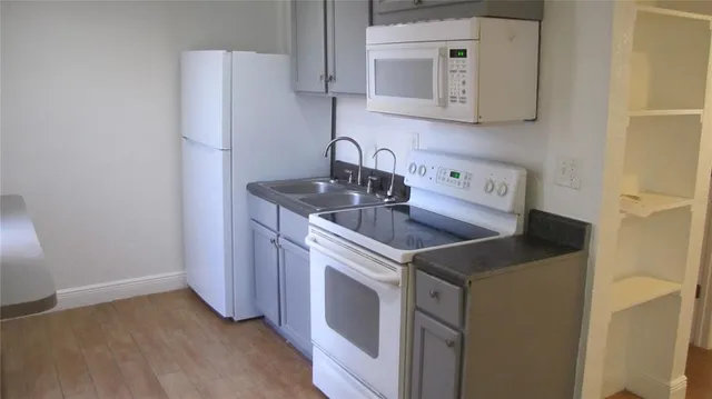 a kitchen with stainless steel appliances granite countertop a sink and a refrigerator