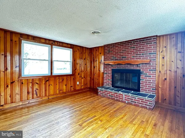 wooden floor fireplace and windows in an empty room