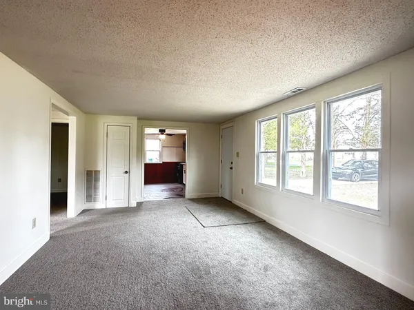 an empty room with windows and closet