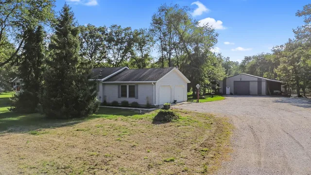 a front view of a house with yard and tree