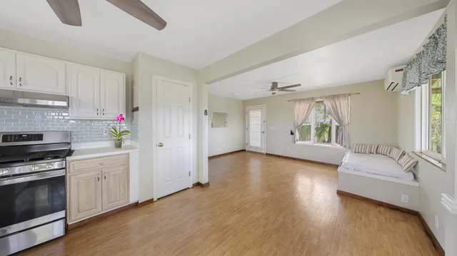 a view of a big room with wooden floor and windows