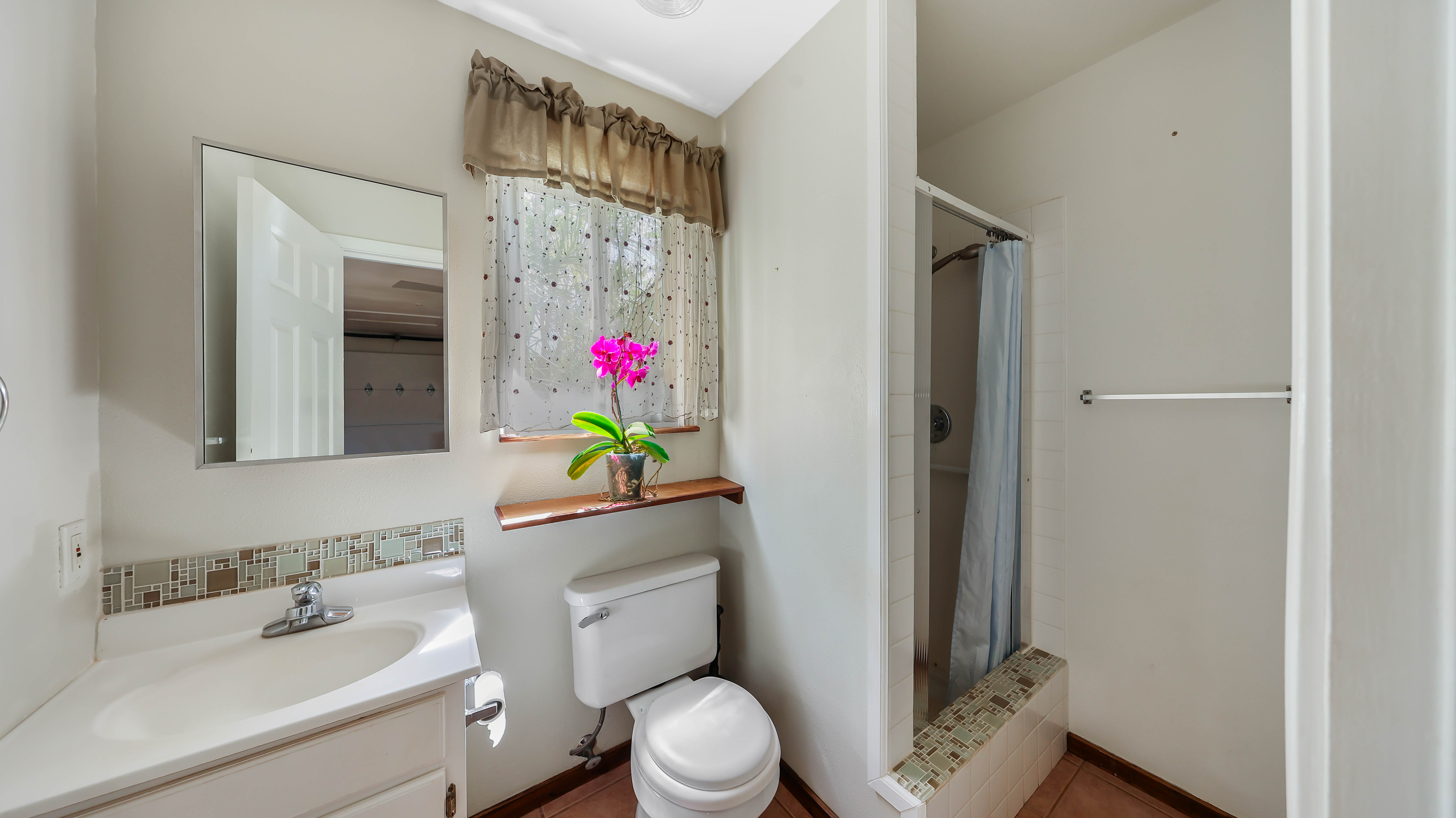 5060 Alii Road Hanapepe, HI 96716 - Photo 18 of 30 a bathroom with a sink mirror vanity and toilet