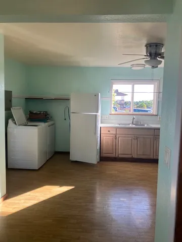 a kitchen with granite countertop white cabinets appliances and a sink