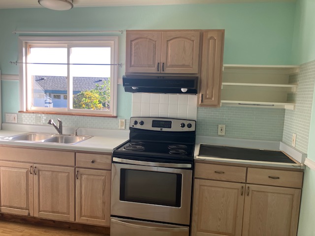 5060 Alii Road Hanapepe, HI 96716 - Photo 27 of 30 a kitchen with granite countertop white cabinets appliances and a sink
