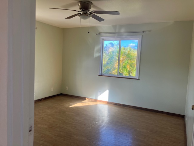 5060 Alii Road Hanapepe, HI 96716 - Photo 28 of 30 an empty room with wooden floor fan and windows