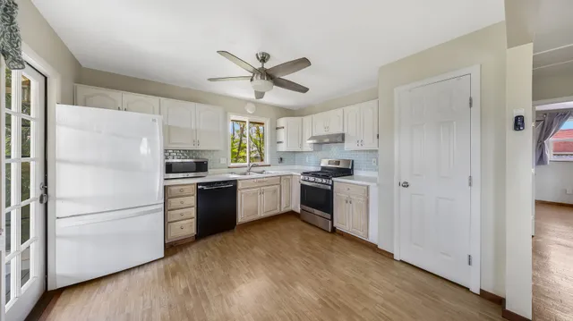 a view of a big room with wooden floor and a kitchen