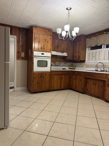 a large kitchen with granite countertop a stove a sink and a refrigerator