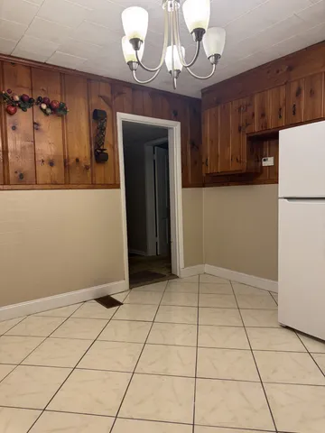a view of an empty room with window and cabinet