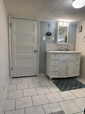 a bathroom with a granite countertop sink a mirror and a bathtub