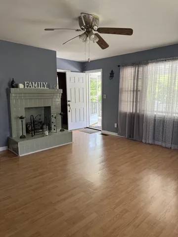 a view of an empty room with a window and a fireplace