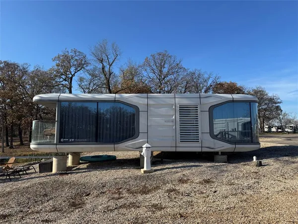 a view of a small house with a yard and wooden fence