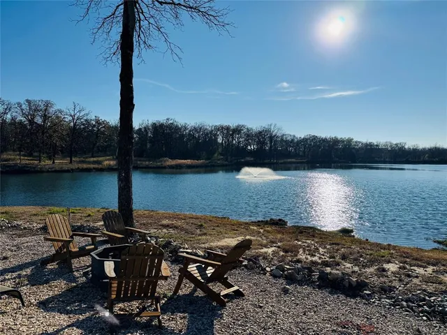 a view of a lake with a table and chairs