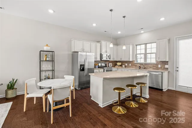 a kitchen with a dining table chairs refrigerator and cabinets