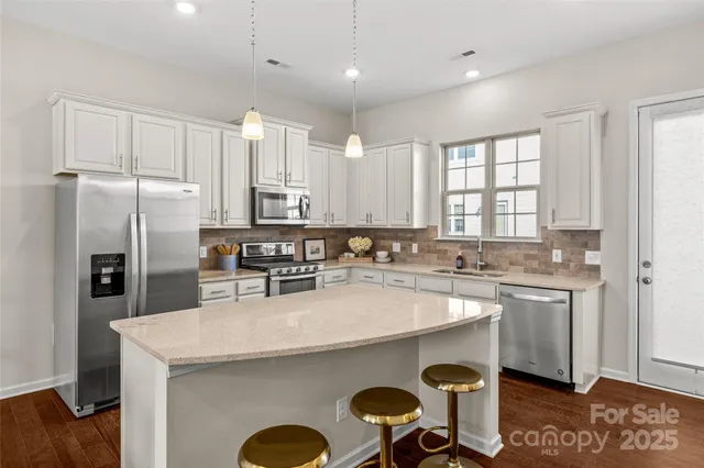 a kitchen with granite countertop a sink a counter space stainless steel appliances and cabinets