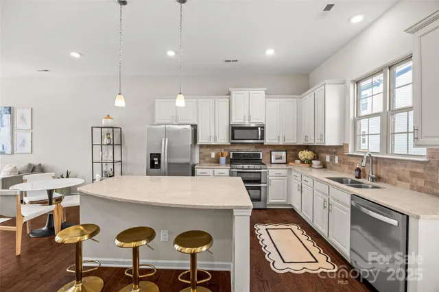 a kitchen with a sink a stove and chairs