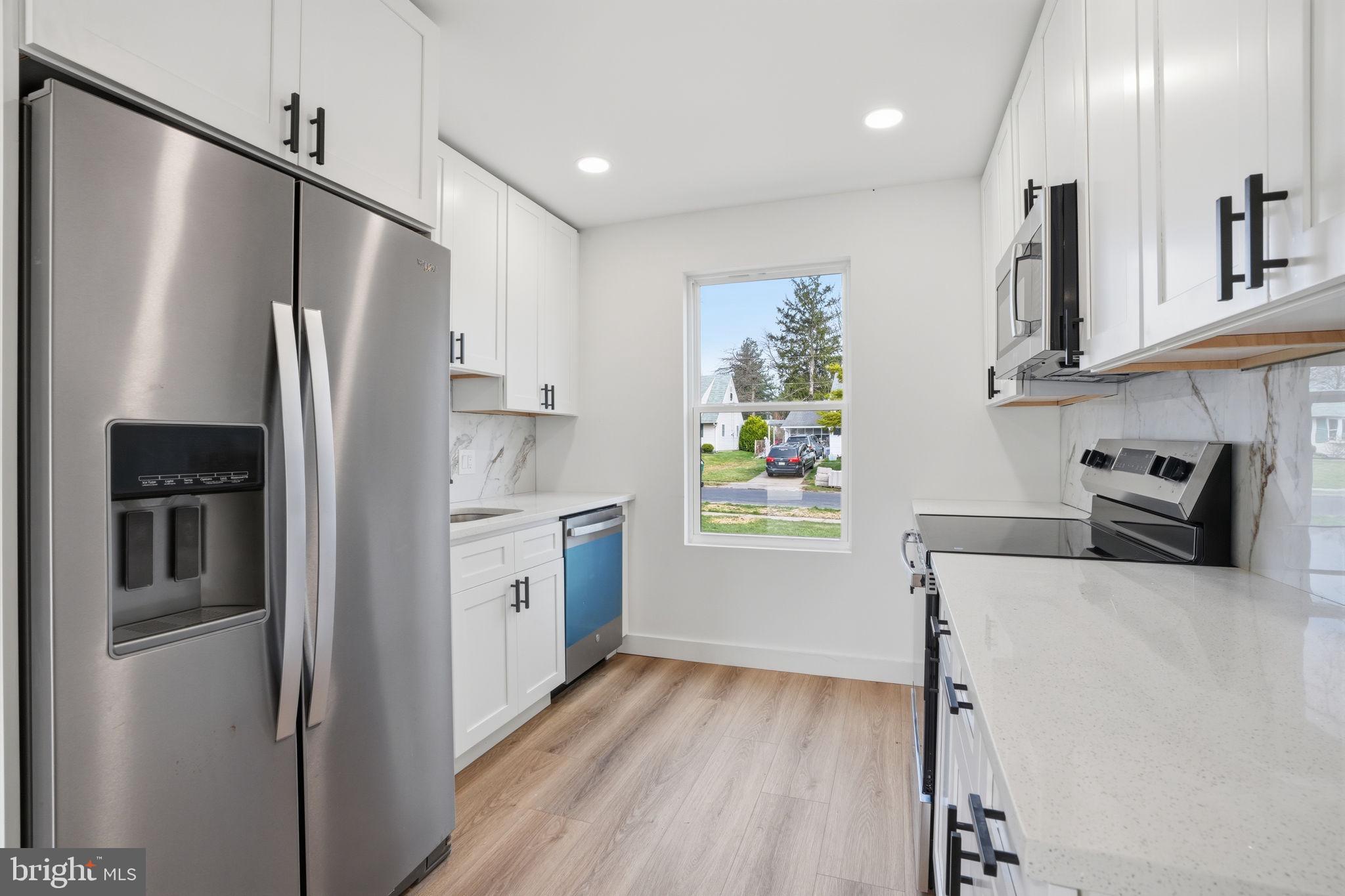 14 Inlet Road Levittown, PA 19057 - Photo 9 of 31 a kitchen with stainless steel appliances a refrigerator sink and wooden floor