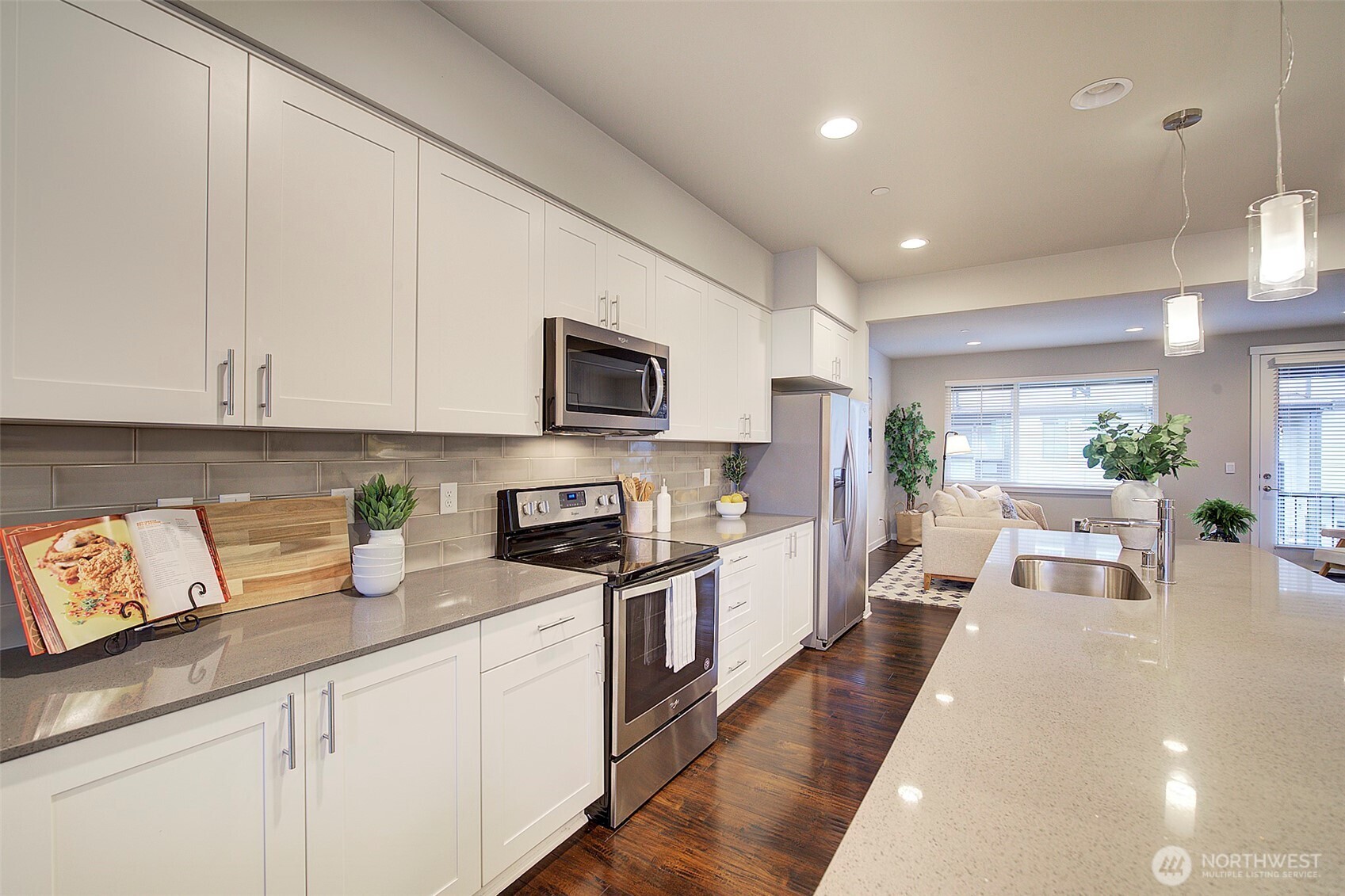 1325 Seattle Hill Road, Unit L2 Bothell, WA 98012 - Photo 16 of 36 a kitchen with stainless steel appliances granite countertop a stove a sink a refrigerator a microwave a dining table and chairs with white cabinets