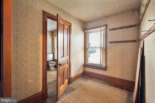a view of a small house with a small yard and wooden fence