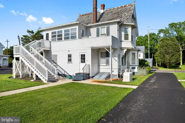 a view of a house with a yard and sitting area
