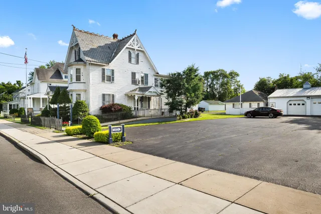 a view of a white house with swimming pool in front of it