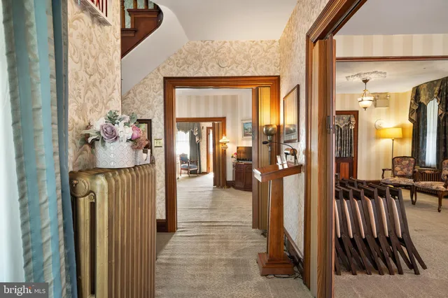 a view of a hallway with wooden floor and living room