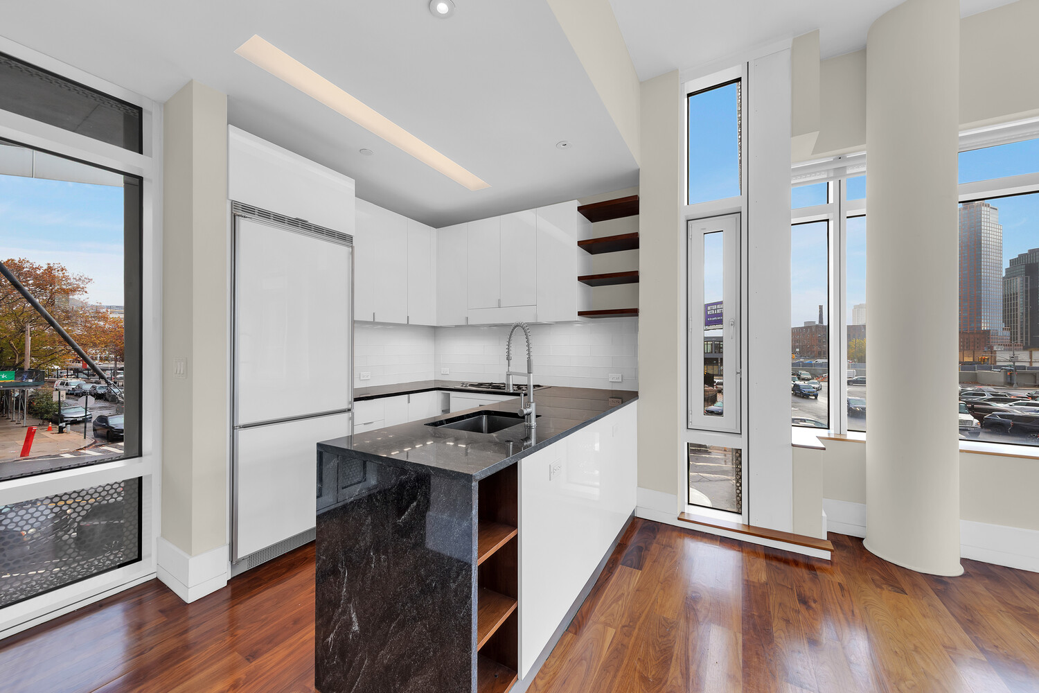 10-17 Jackson Avenue, Unit 2C Queens, NY 11101 - Photo 2 of 6 a kitchen with granite countertop a stove and a refrigerator