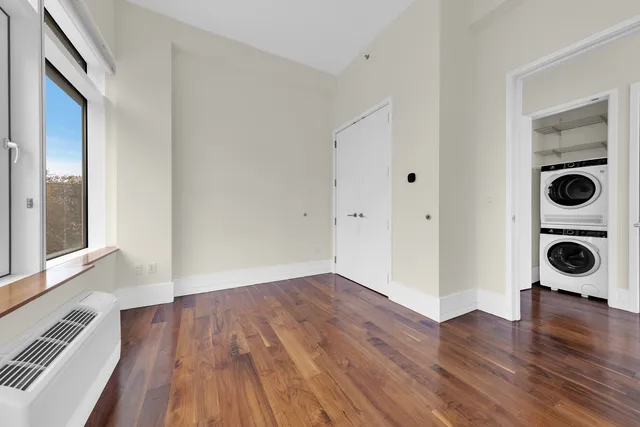 a view of empty room with wooden floor