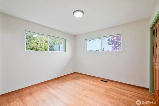 a view of empty room with wooden floor