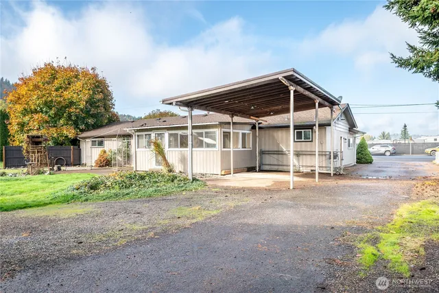 a front view of a house with a garden and trees