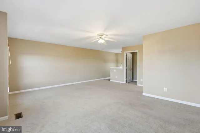 an empty room with a ceiling fan and a window