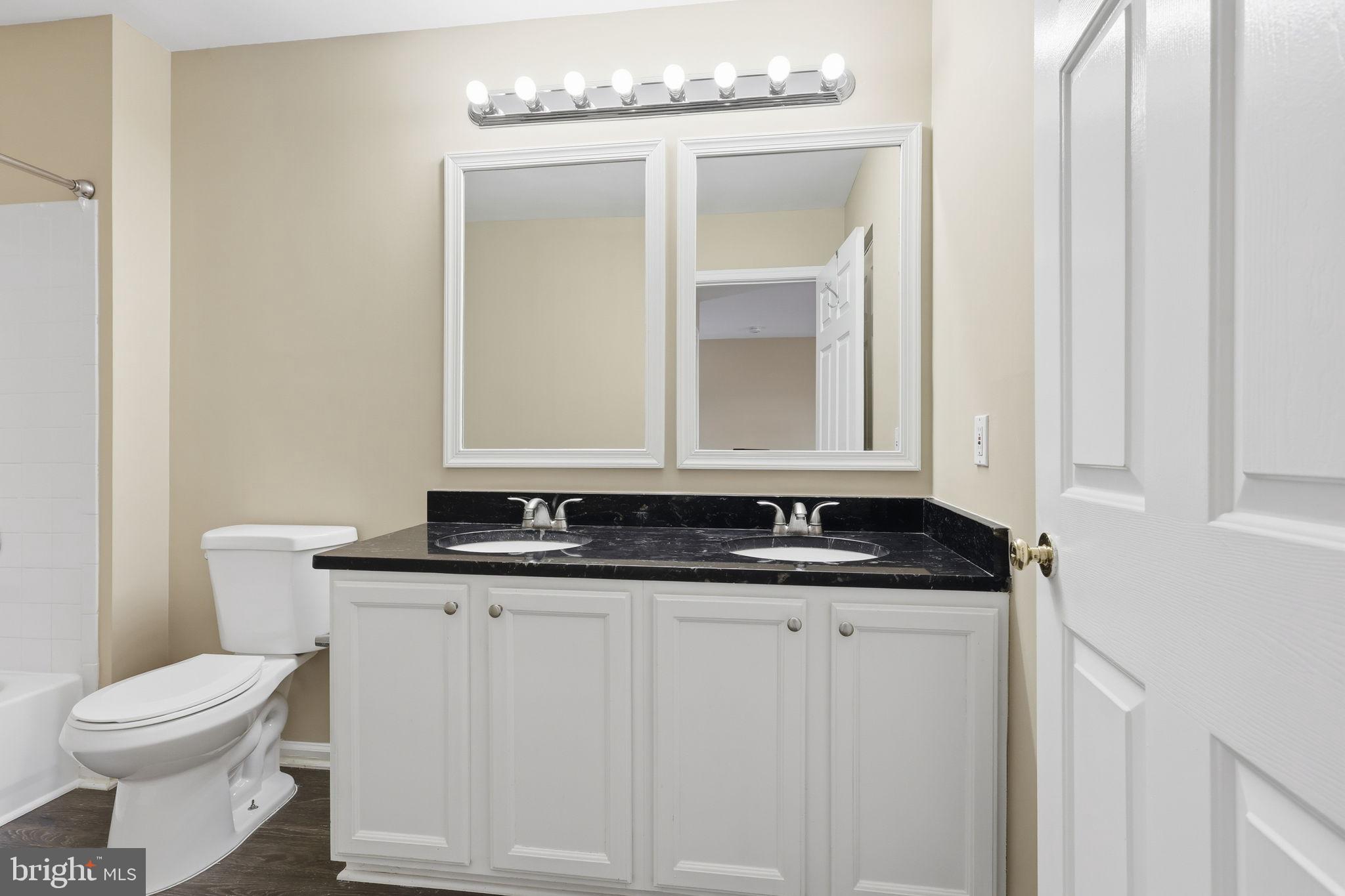 9304 Witch Hazel Way Manassas, VA 20110 - Photo 21 of 45 a bathroom with a granite countertop toilet a sink and a mirror