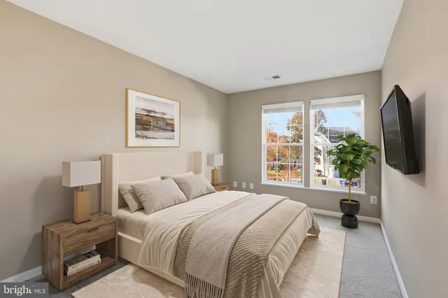 a bedroom with a bed a flat screen tv and window