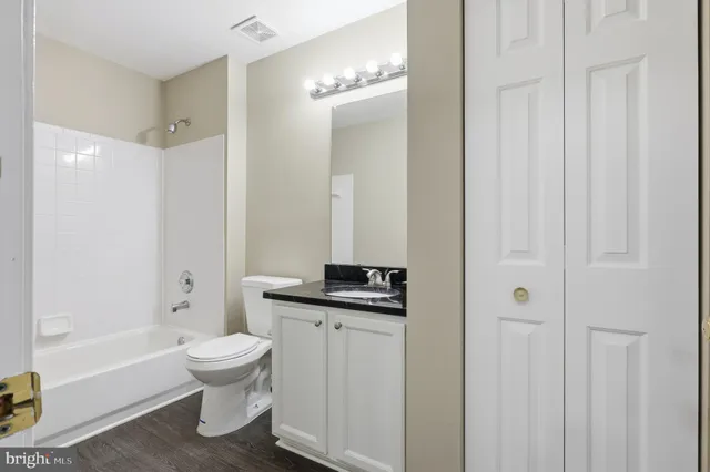 a bathroom with a granite countertop sink a toilet and shower