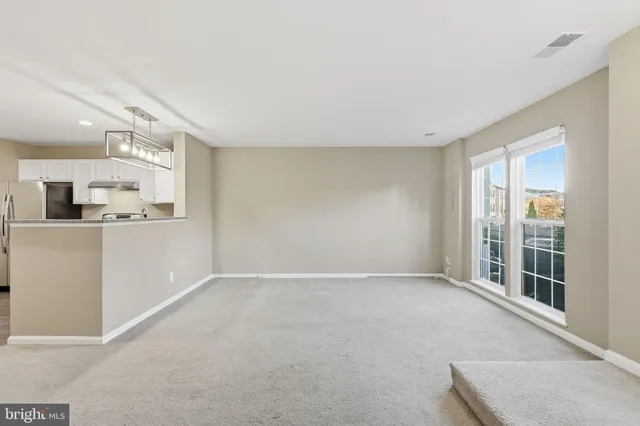 a view of a kitchen with refrigerator and windows