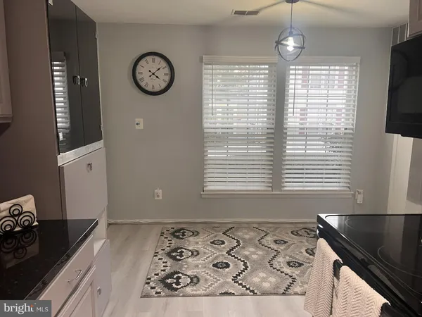 a view of a kitchen with wooden floor and a window