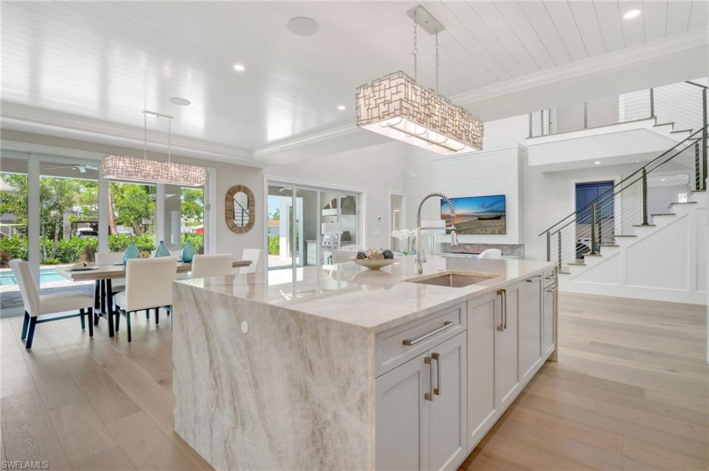1308 Ridge Street Naples, FL 34103 - Photo 17 of 48 a large kitchen with kitchen island a large window a sink and cabinets