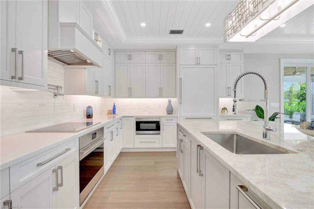 1308 Ridge Street Naples, FL 34103 - Photo 19 of 48 a kitchen with granite countertop a sink and white cabinets