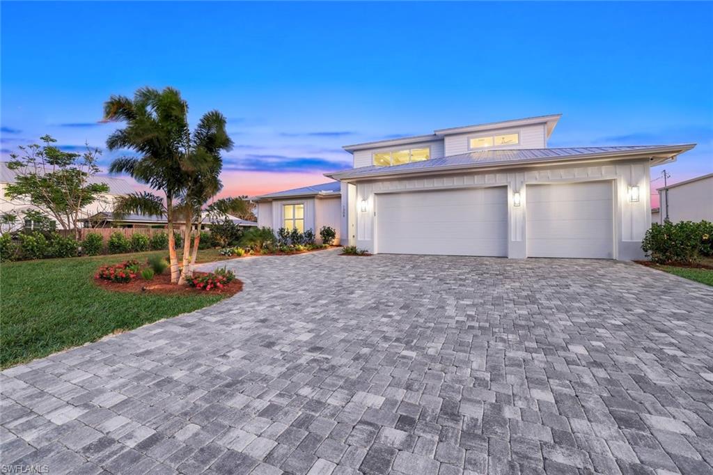 1308 Ridge Street Naples, FL 34103 - Photo 43 of 48 a front view of a house with a yard and a garage