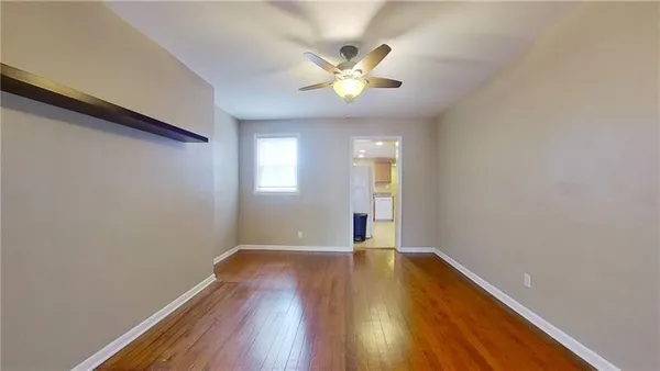 a view of wooden floor and a chandelier fan in a room
