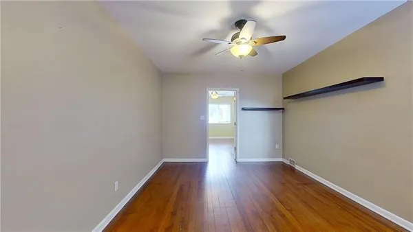 a view of empty room with wooden floor