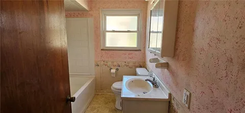 a bathroom with a sink toilet and mirror