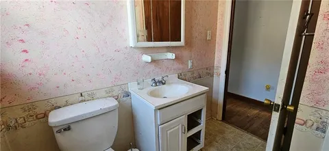 a bathroom with a granite countertop bathtub shower sink vanity and toilet