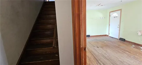 a view of a hallway with wooden floor and staircase