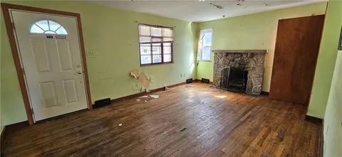 an empty room with windows and a fireplace