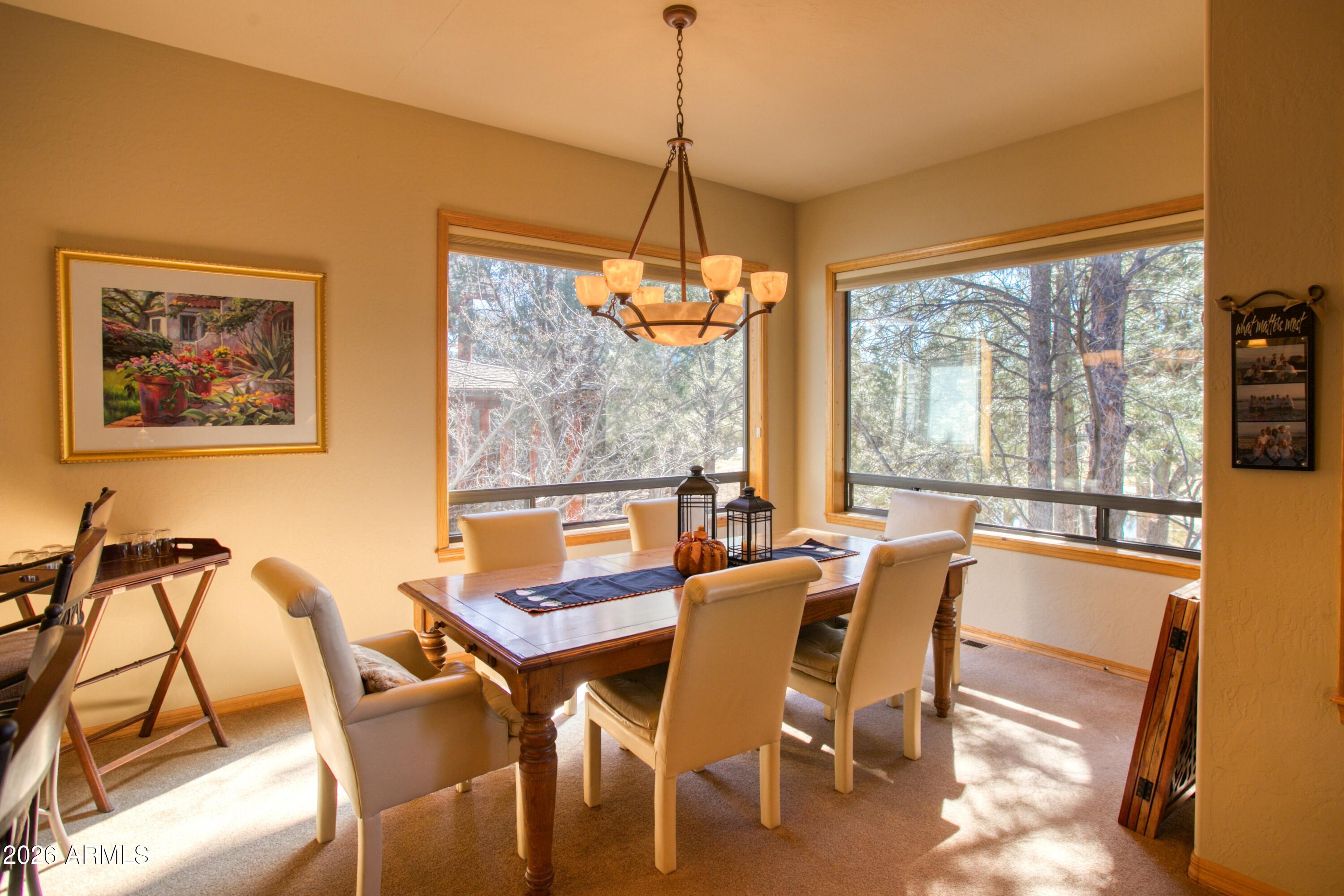 3990 Sugar Pine Loop Show Low, AZ 85901 - Photo 11 of 62 a dining room with furniture a chandelier and large windows