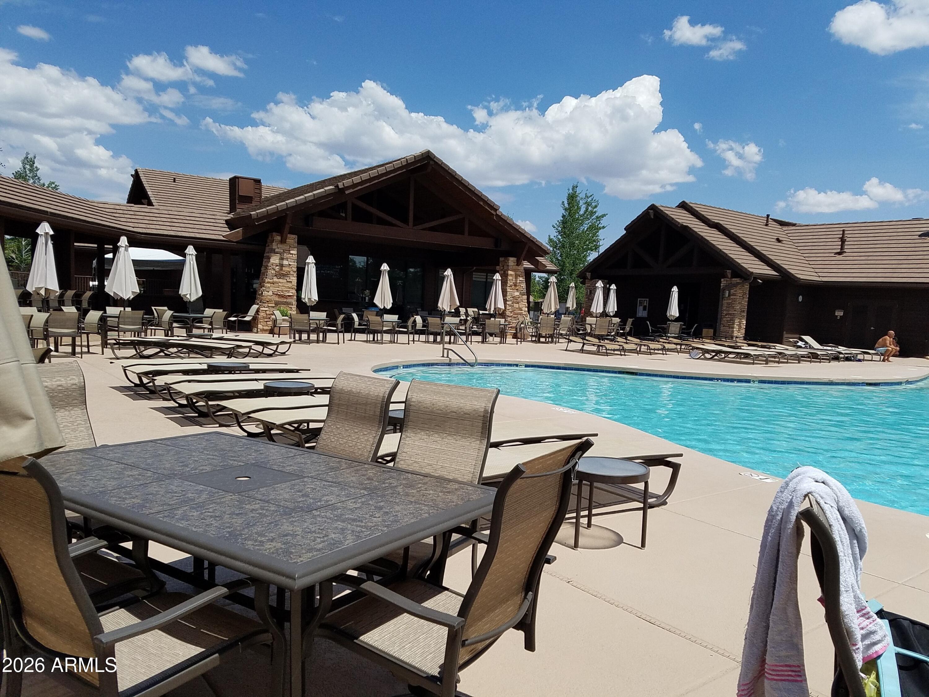 3990 Sugar Pine Loop Show Low, AZ 85901 - Photo 45 of 62 a view of a patio with dining table and chairs with wooden floor and fence