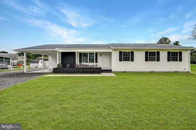 a front view of house with yard and outdoor seating