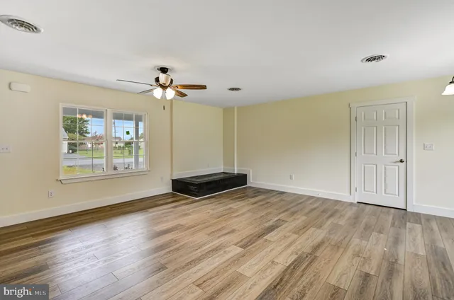 wooden floor in an empty room with a window